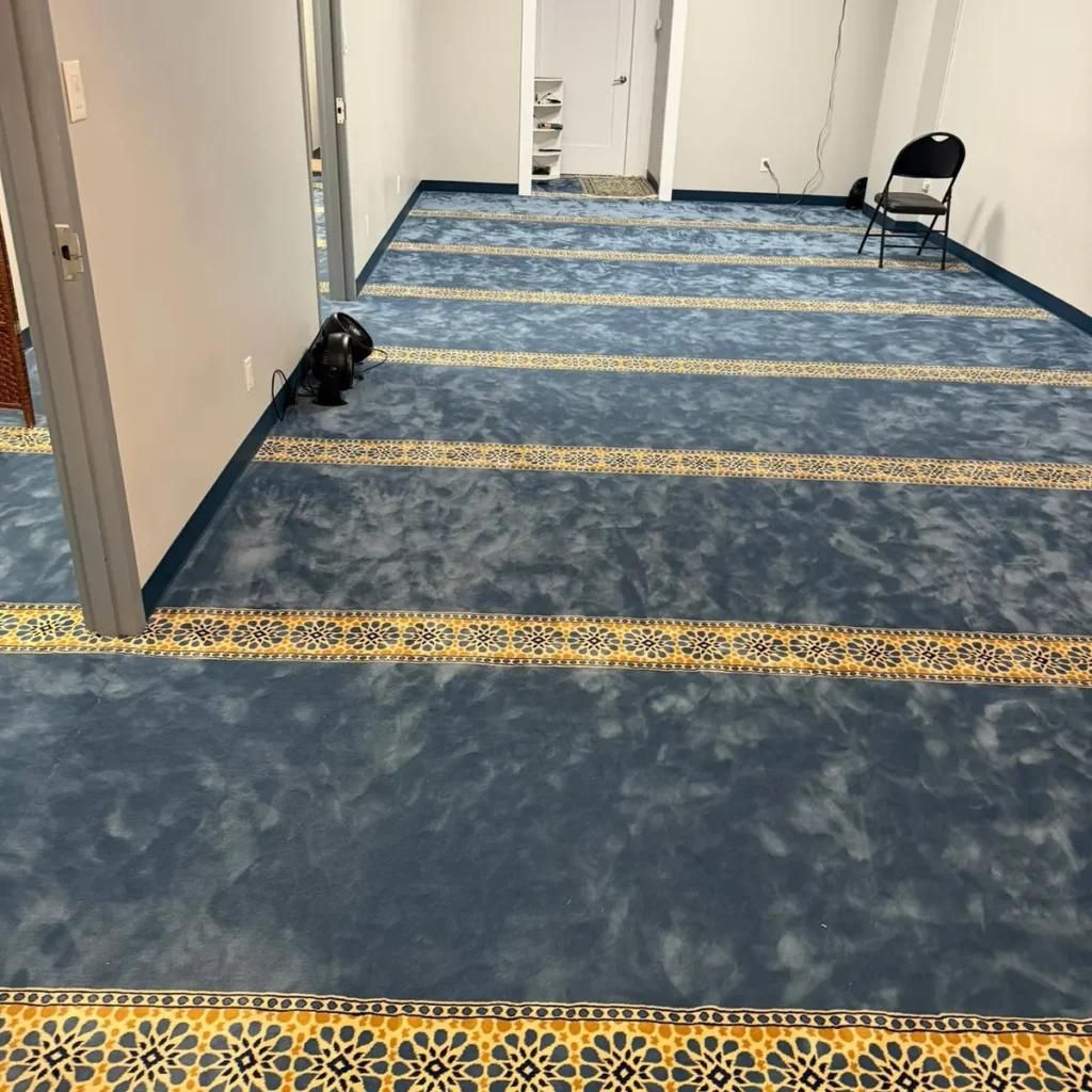 Blue carpet with gold patterned bands in a large community room
