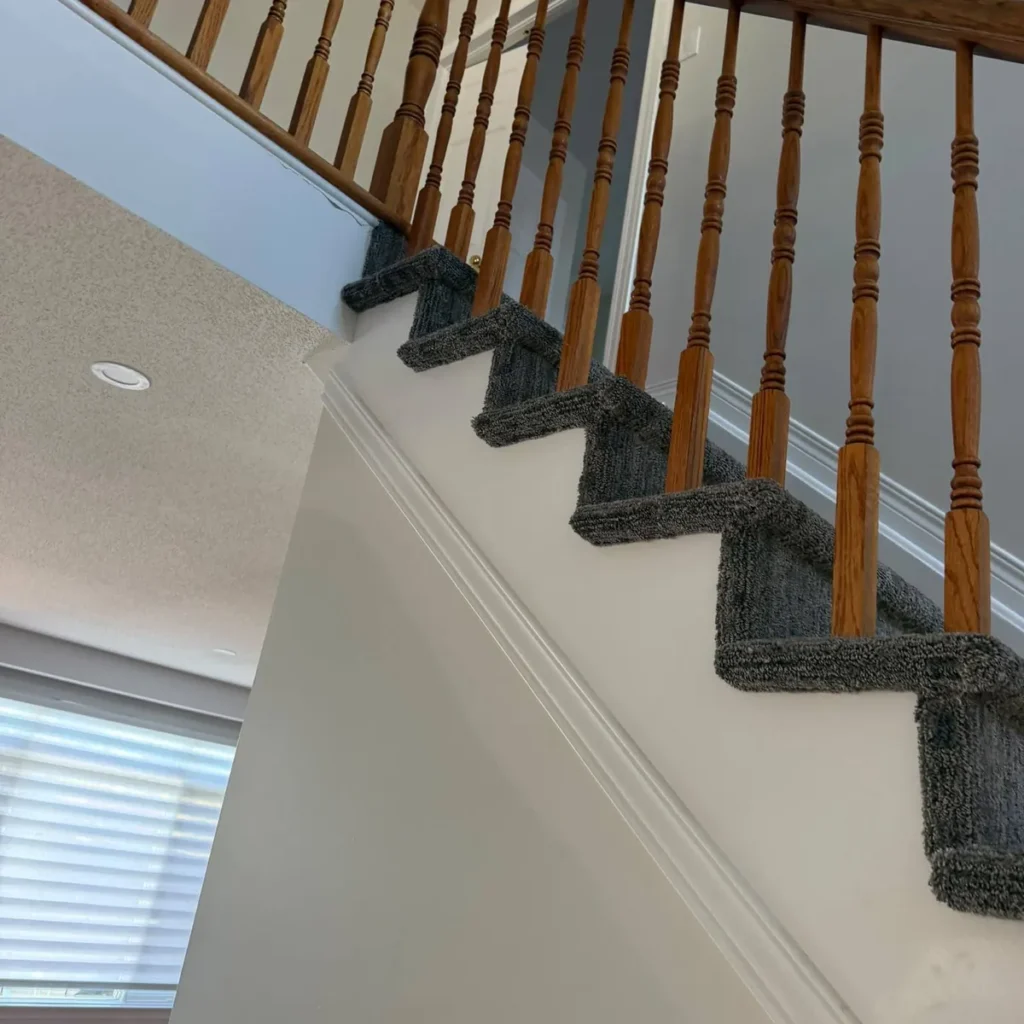 Grey carpet wrapped around the open side of each stair